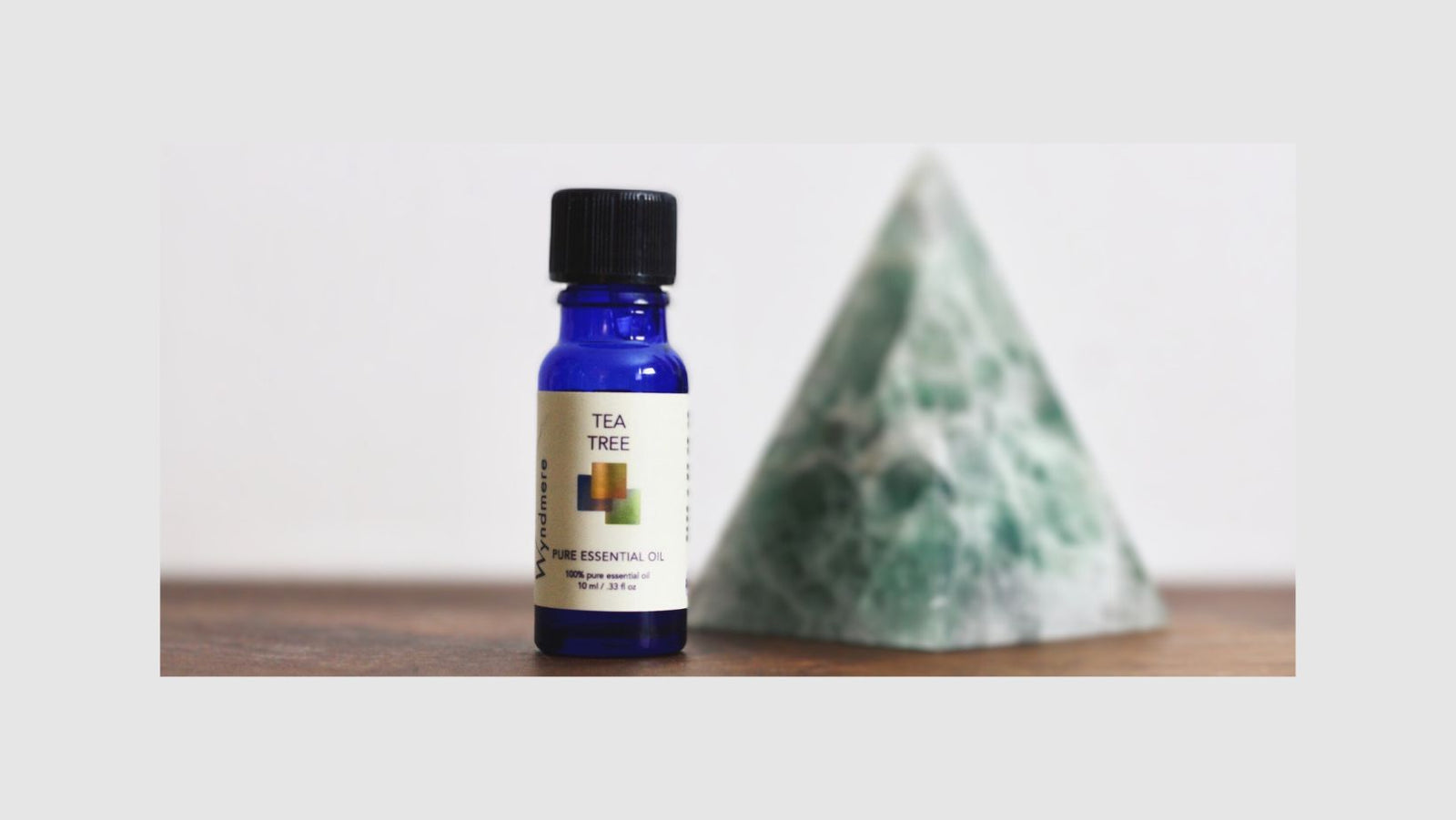 Wyndmere Tea Tree essential oil bottle with green crystal pyramid