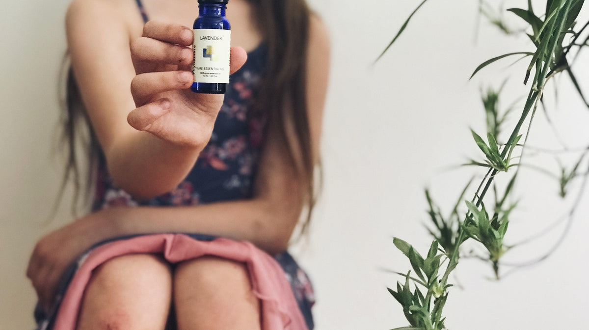 Sitting girl holding Wyndmere lavender essential oil