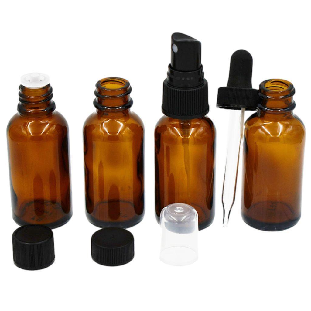 Grouping of 1oz amber boston round glass bottles with various closures .