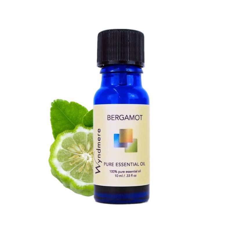 Slice of the Bergamot fruit with a 10ml cobalt blue bottle of Wyndmere Bergamot Essential Oil