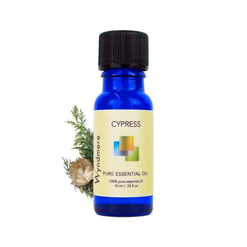 Cypress branch with a 10ml cobalt blue bottle of Wyndmere Cypress Essential Oil