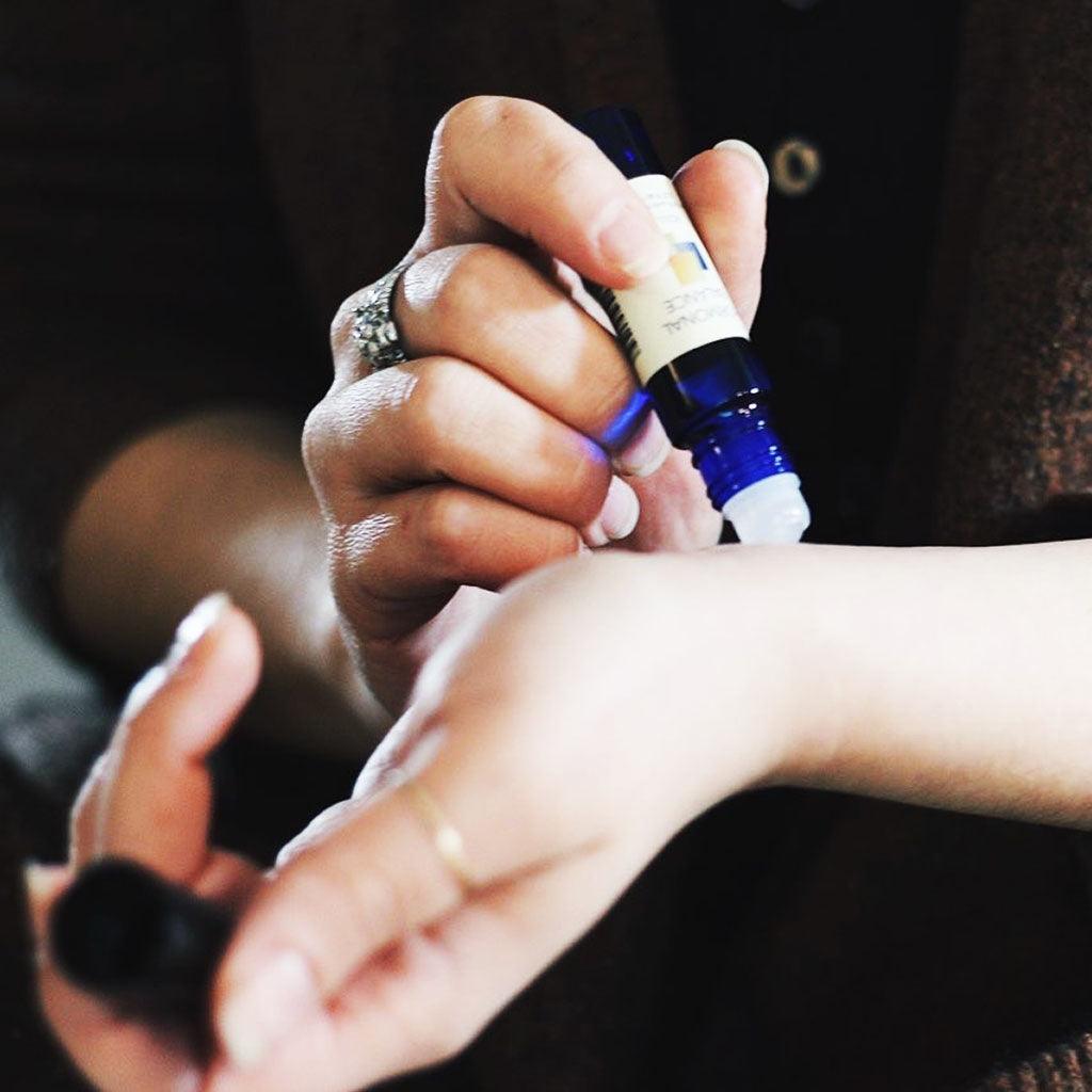 A woman applying Hormonal Balance on her wrist pulse point