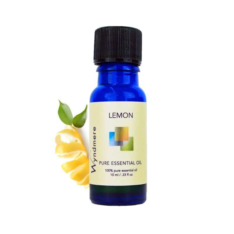 Curled lemon peel with a 10ml cobalt blue bottle of Wyndmere Lemon Essential Oil that has a citrus, uplifting aroma