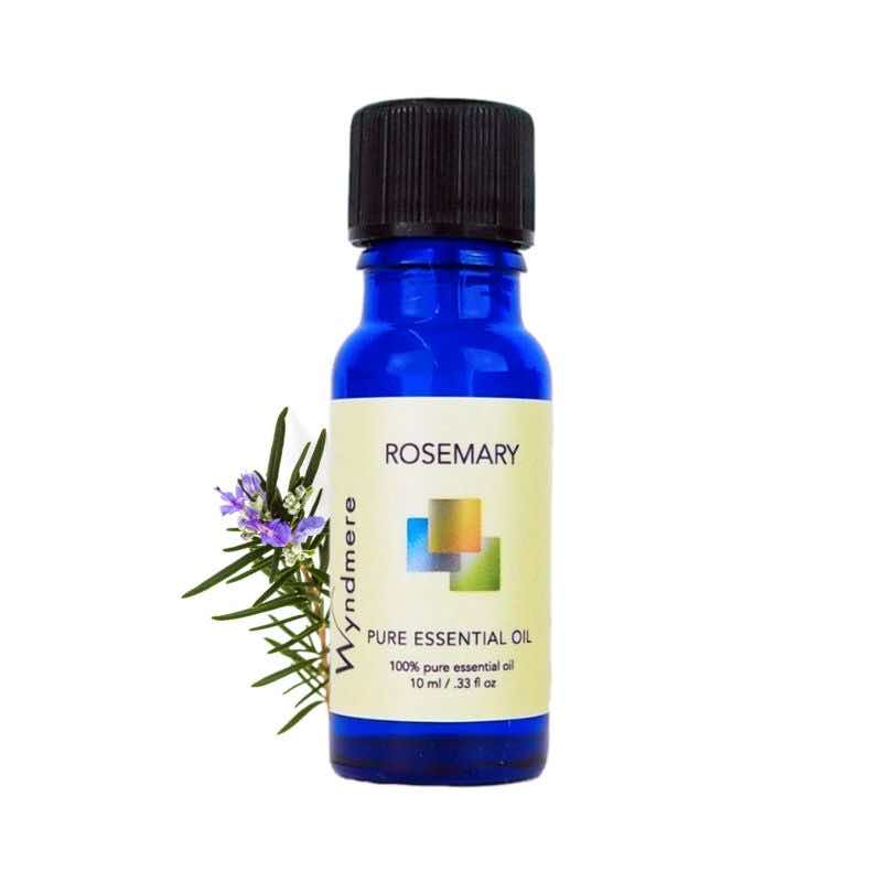 Rosemary sprig with a 10ml cobalt blue bottle of Wyndmere Rosemary Essential Oil