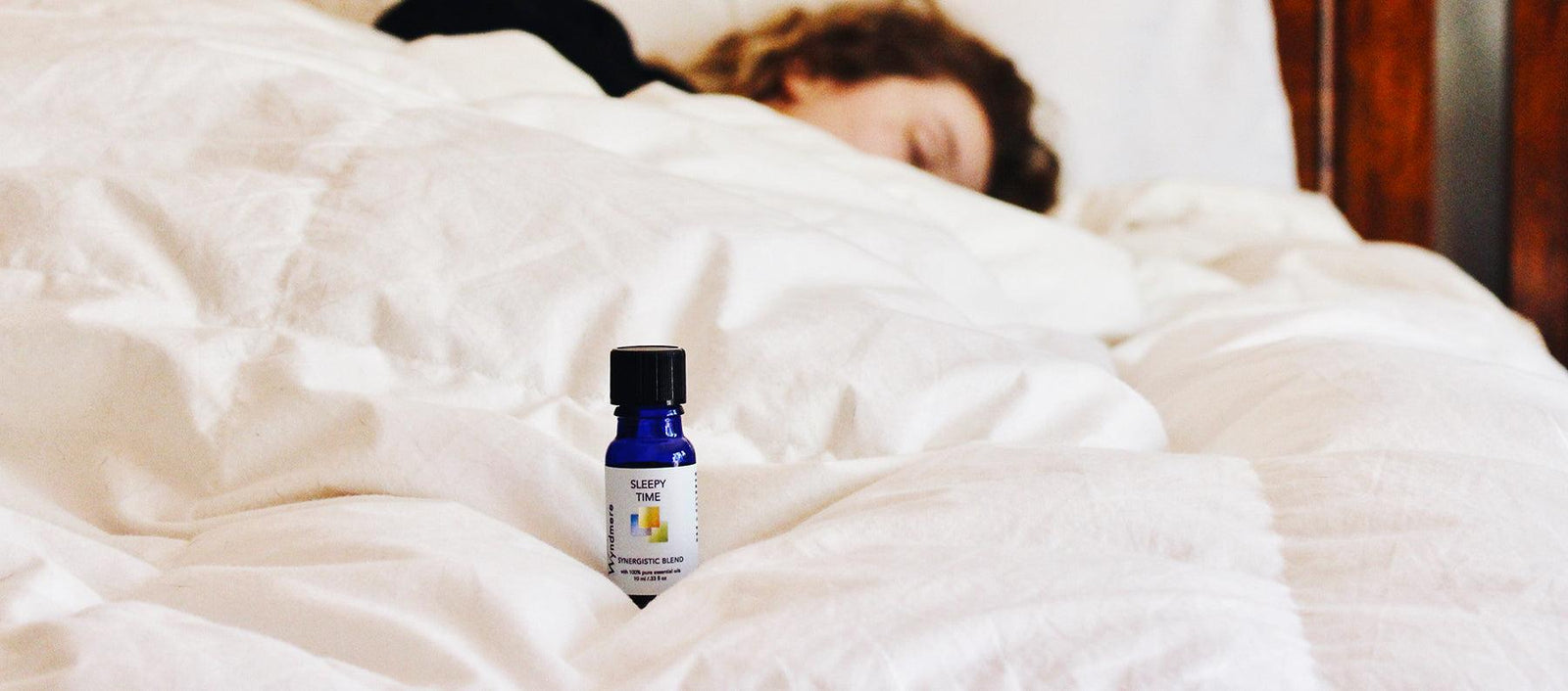 Woman sleeping in bed. Essential oils can help you get a good night's sleep. 