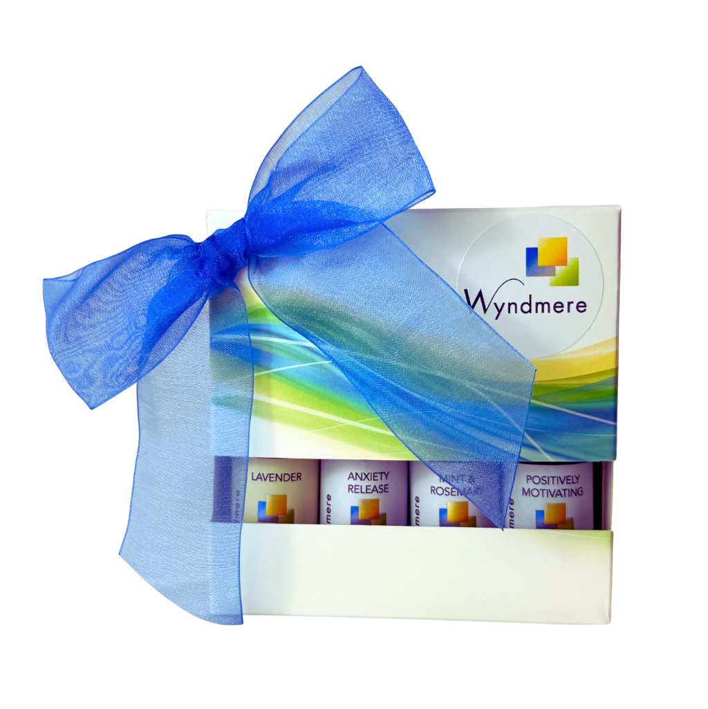 Wyndmere essential oil product set with colorful packaging and blue ribbon on a white background