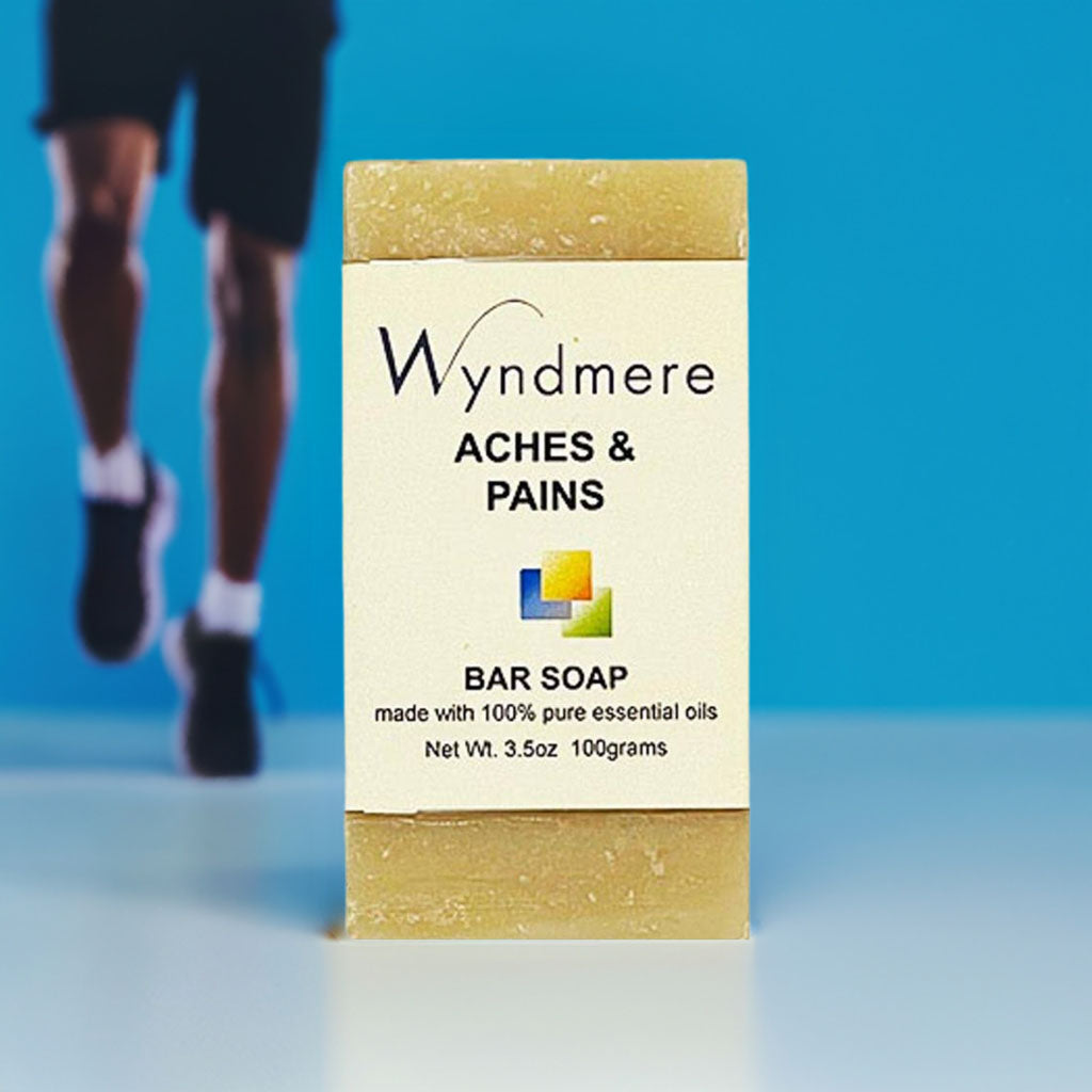 Wyndmere Aches & Pains bar soap packaging with a person walking in the background.
