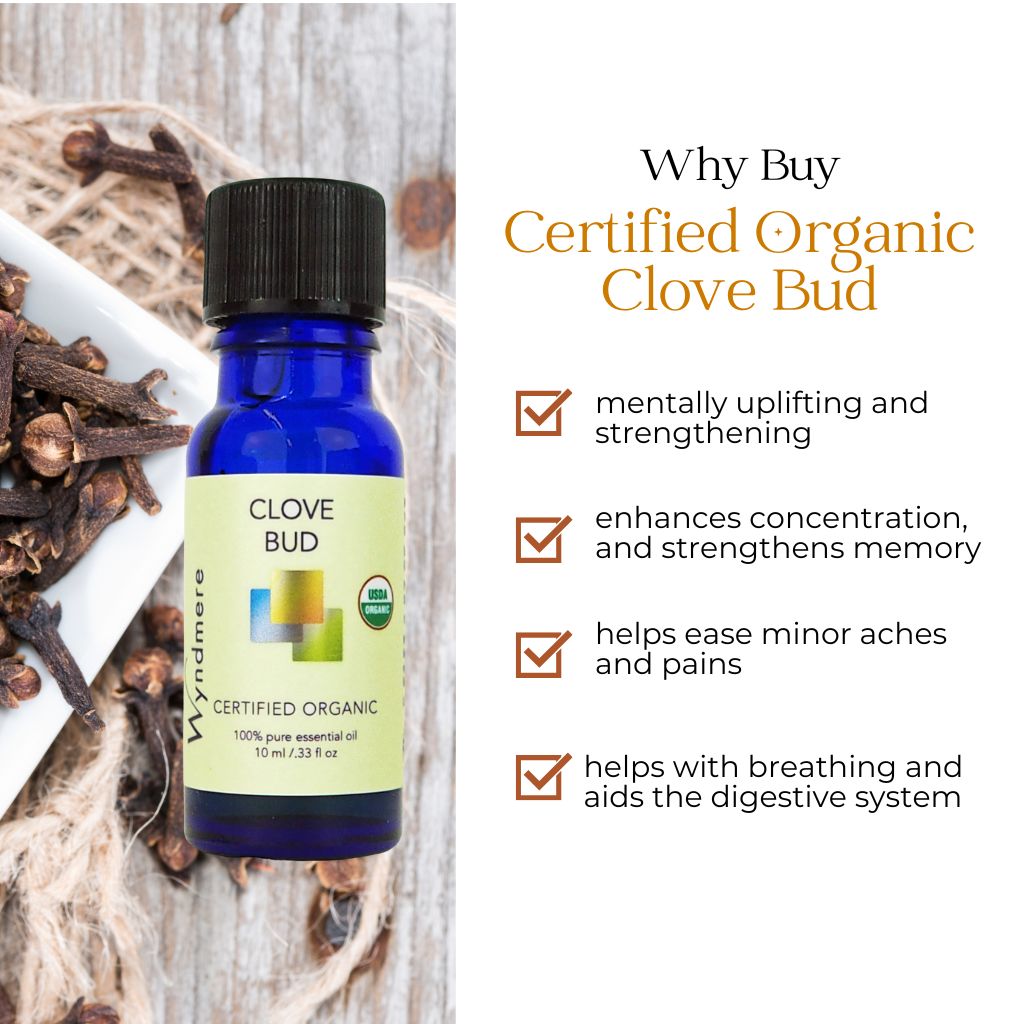 Bottle of Wyndmere certified organic clove bud essential oil with benefits listed on a wooden background
