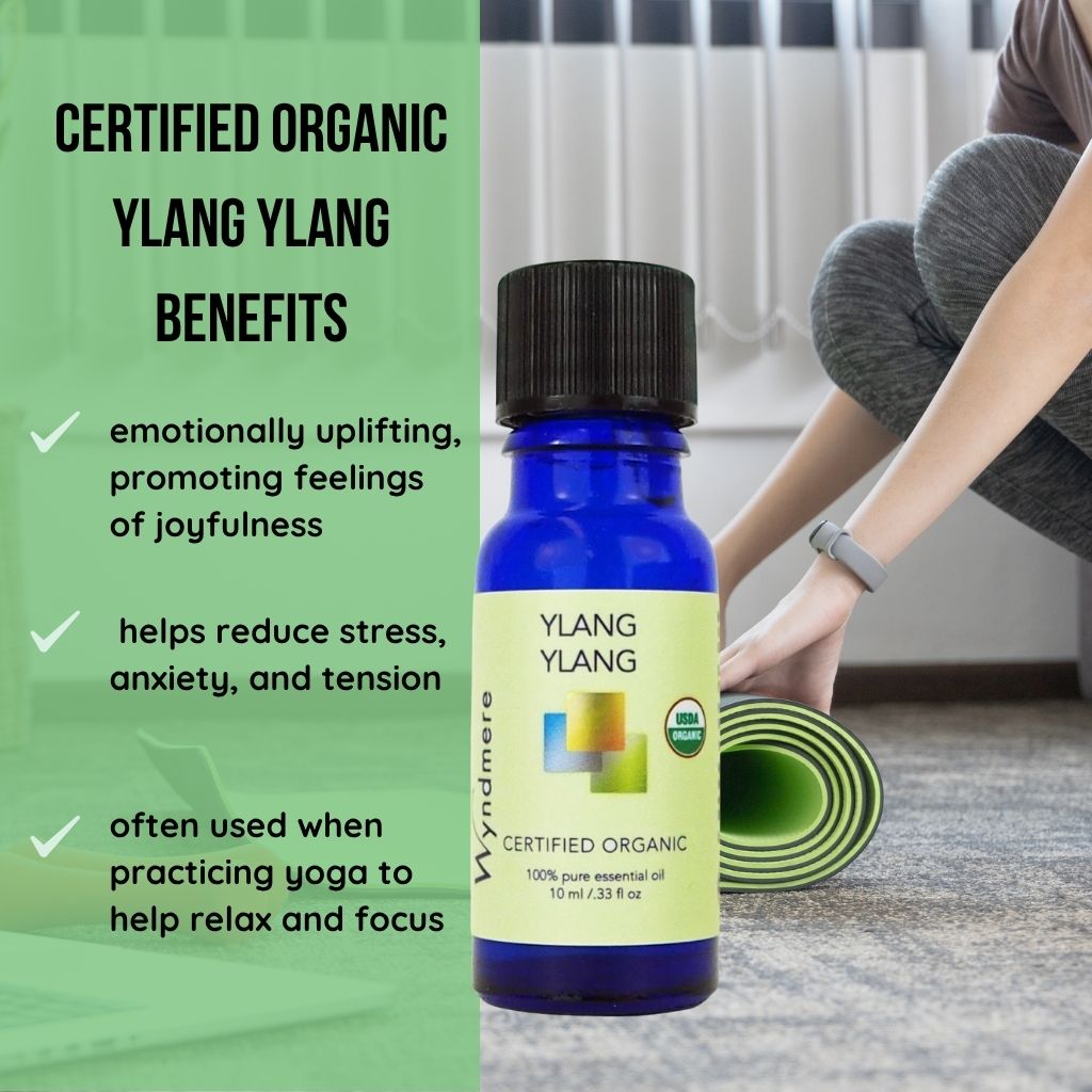 Wyndmere certified organic Ylang ylang essential oil bottle with benefits list and person practicing yoga in the background