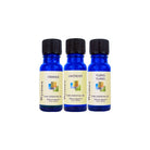 Orange, Lavender, and Ylang Ylang essential oils in blue bottles on a white background.