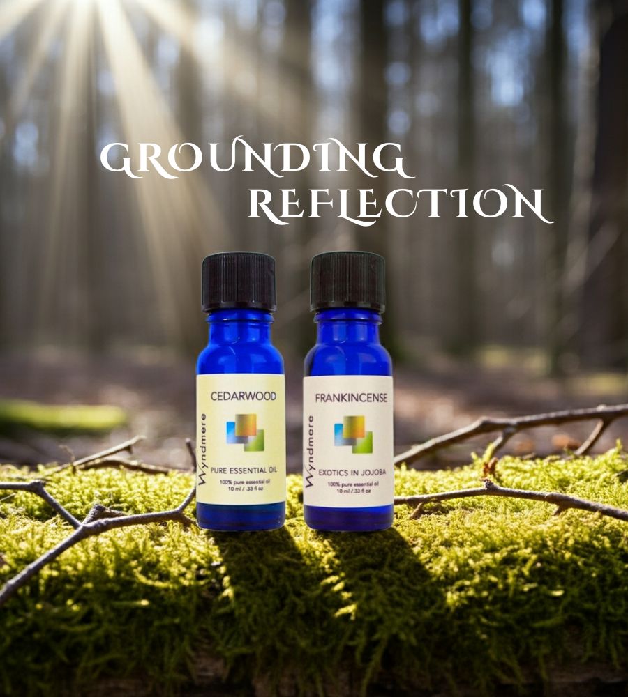 Two essential oil bottles, Cedarwood and Frankincense, on a stone circle in a forest setting with 'Grounding Reflection' text.