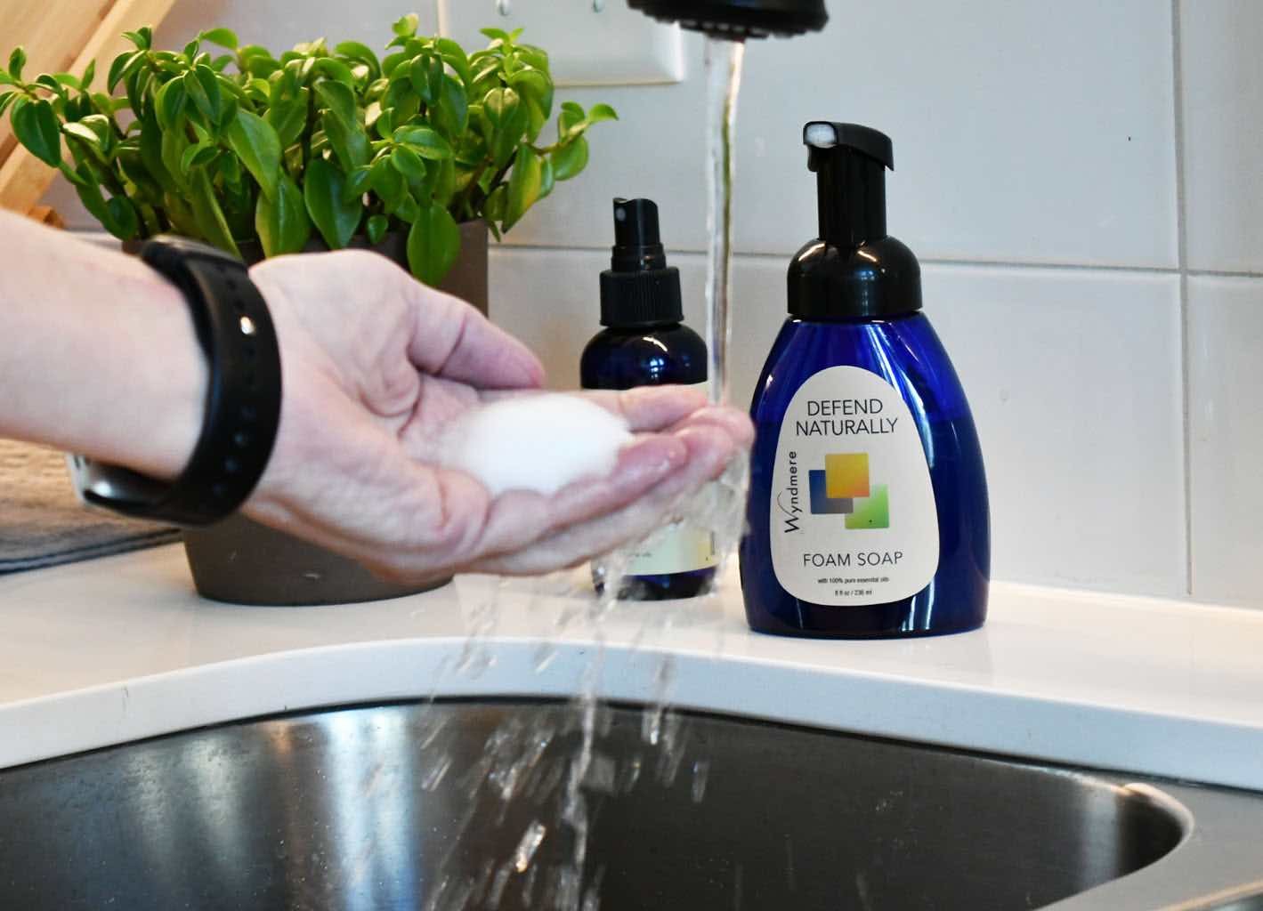 Defend Naturally Foam Soap in hand with running water.