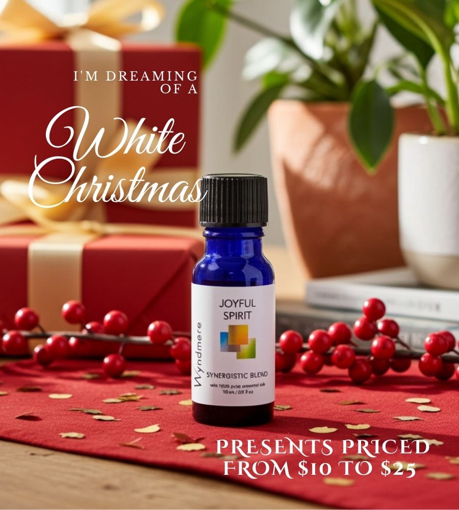 Bottle of 'Wyndmere Joyful Spirit' essential oil blend on a table with Christmas decorations.
