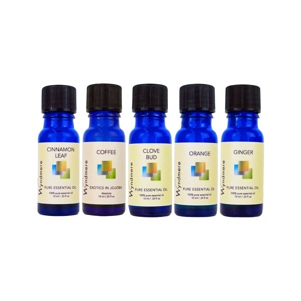 Five blue essential oil bottles with black lids on a white background - Wyndmere