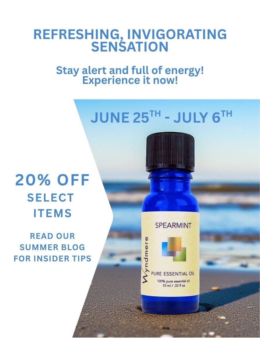Wyndmere - Pictured is spearmint essential oil sitting on a sandy beach with waves in the background. 