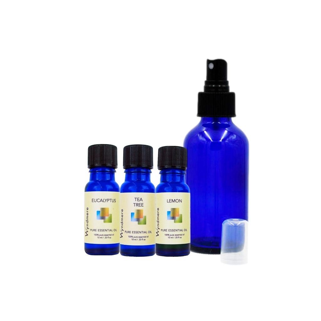 Set of Wyndmere essential oil bottles with a blue spray bottle on a white background