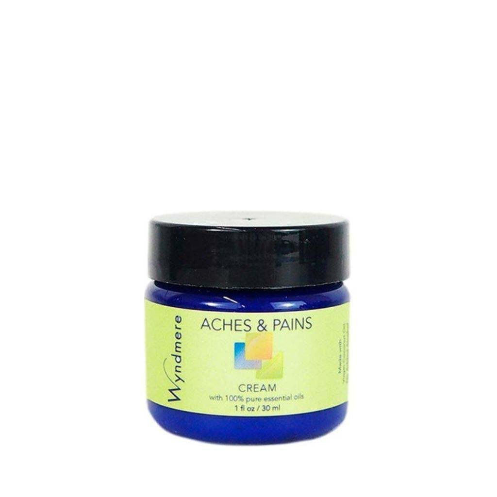 A 1oz cobalt blue jar of Wyndmere Aches & Pains moisturizing cream with the best essential oils for sore muscles
