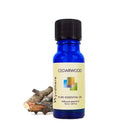Cedar logs with a 10ml cobalt blue bottle of Wyndmere Cedarwood Essential Oil