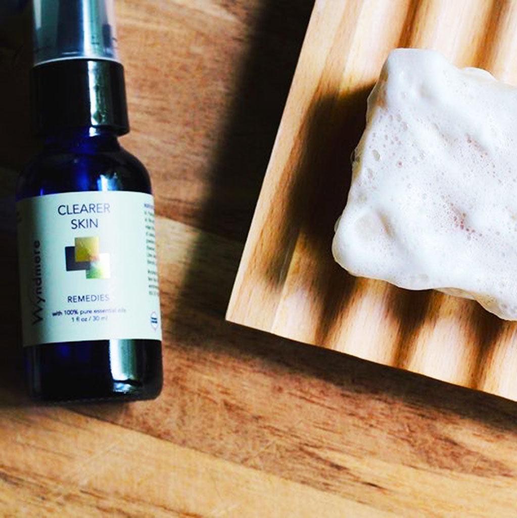 Sudsy bar of Clearer Skin soap near a bottle of Clearer Skin Remedy