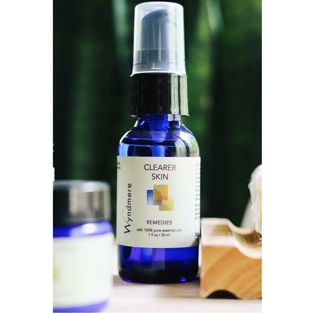 Bottle of Clearer Skin remedy near jar of cream and bar of soap