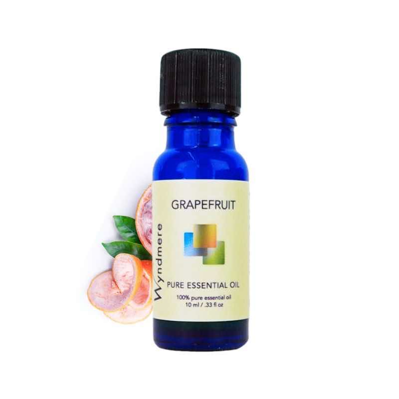 Slices of grapefruit with a 10ml cobalt blue bottle of Wyndmere Grapefruit Essential Oil