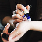 A woman applying Hormonal Balance on her wrist pulse point