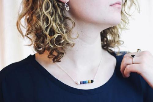 model wearing aromatherapy necklace of multicolored lava beads on a silver chain