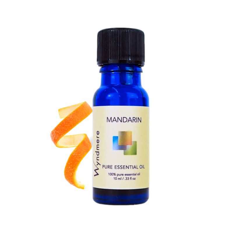 Curly mandarin peel with a 10ml cobalt blue bottle of Wyndmere Mandarin Essential Oil