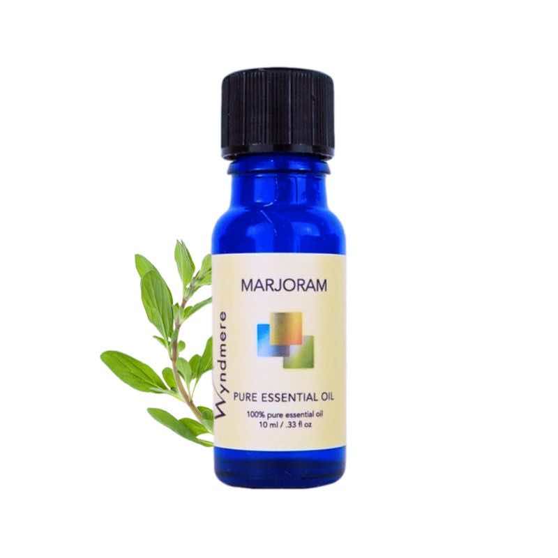 Marjoram sprig with a 10ml cobalt blue bottle of Wyndmere Marjoram Essential Oil