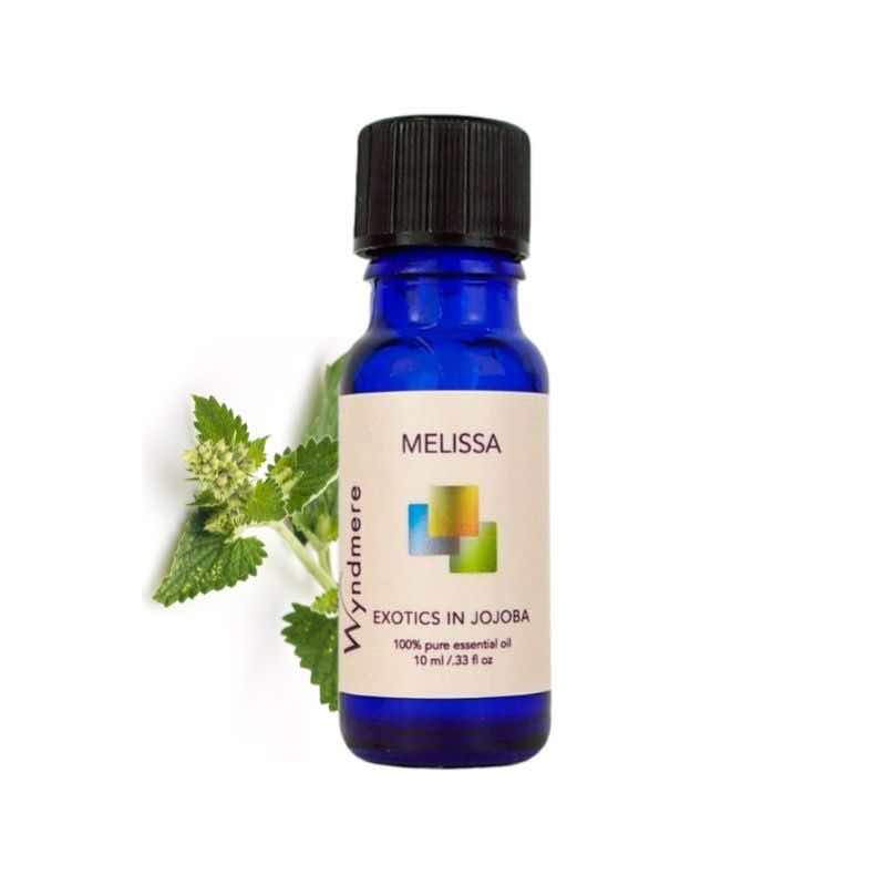 Flowering top of melissa with Wyndmere Melissa Essential Oil diluted in Jojoba in a 10ml cobalt blue bottle