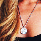 model wearing aromatherapy necklace with lacy silver locket pendant on a silver chain