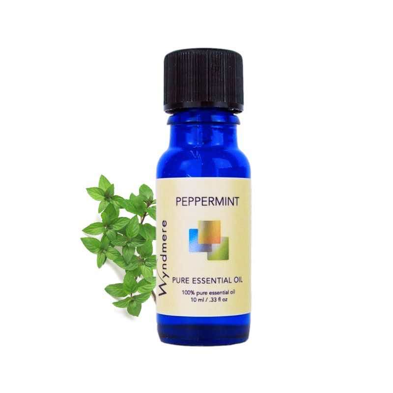 Peppermint leaves with a 10ml cobalt blue bottle of Wyndmere Peppermint Essential Oil