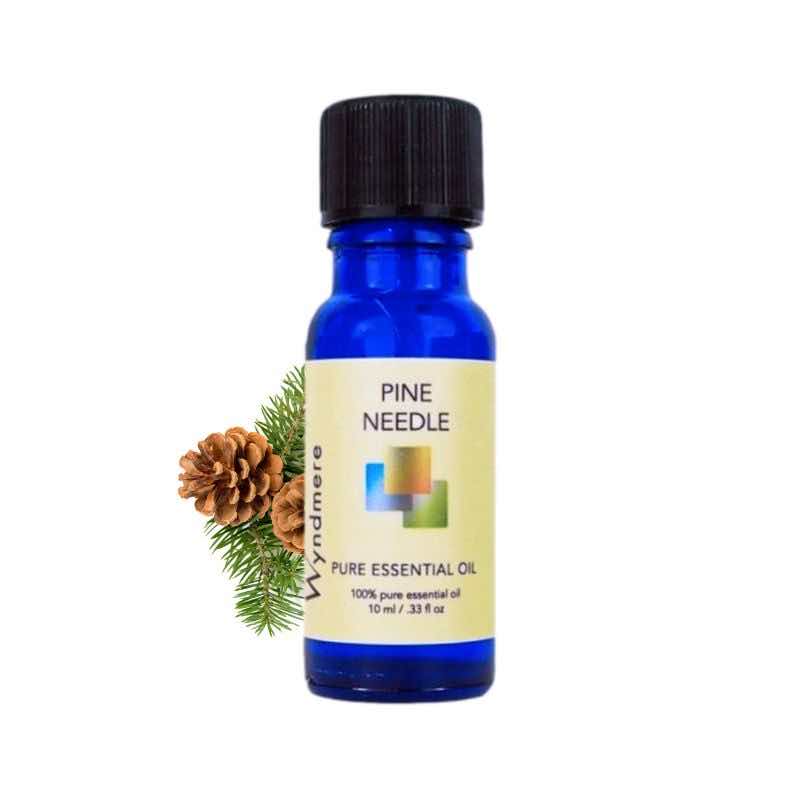Pine branch and cones with a 10ml cobalt blue bottle of Wyndmere Pine Needle Essential Oil