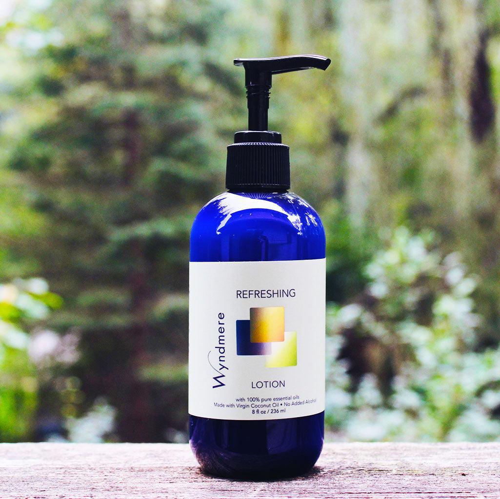 Refreshing Lotion in an 8oz cobalt blue bottle with woods in the background