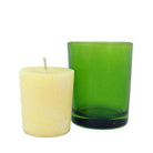 Relaxing votive candle next to green straight walled votive candle holder