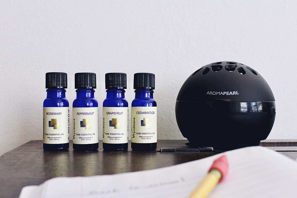 Bottles of rosemary, peppermint, grapefruit and cedarwood essential oils with an AromaPearl diffuser