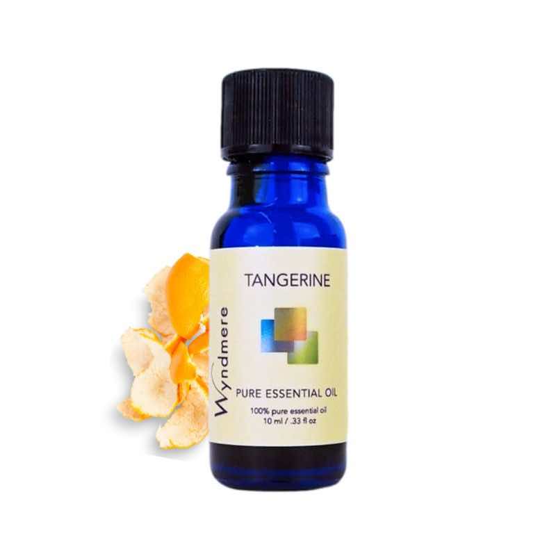 Tangerine sections and peel with a 10ml cobalt blue bottle of Wyndmere Tangerine Essential Oil