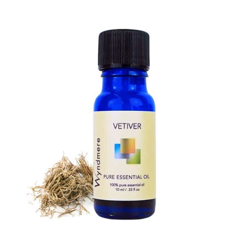 Vetiver roots with a 10ml cobalt blue bottle of Wyndmere Vetiver Essential Oil