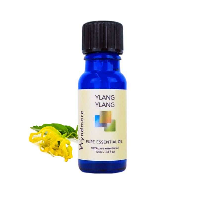 Ylang Ylang flower and leaves with a 10ml cobalt blue bottle of Wyndmere Ylang Ylang Essential Oil